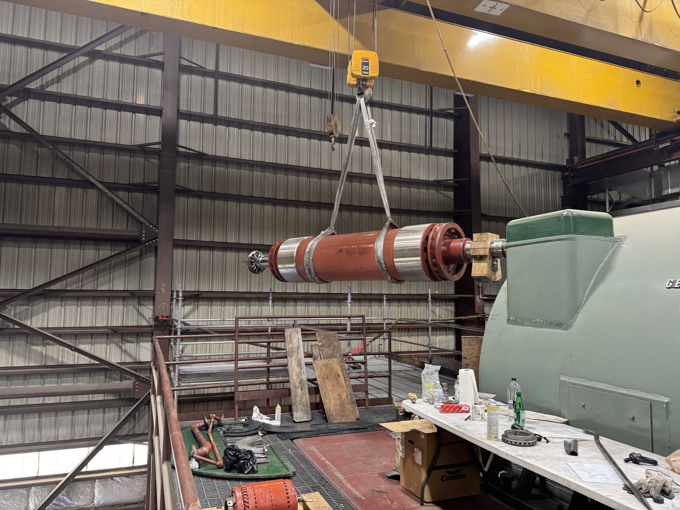 Generator rotor being lifted by overhead crane during field work